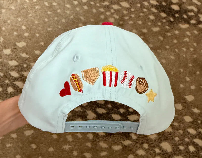 White cap with colorful embroidered designs on a brown surface