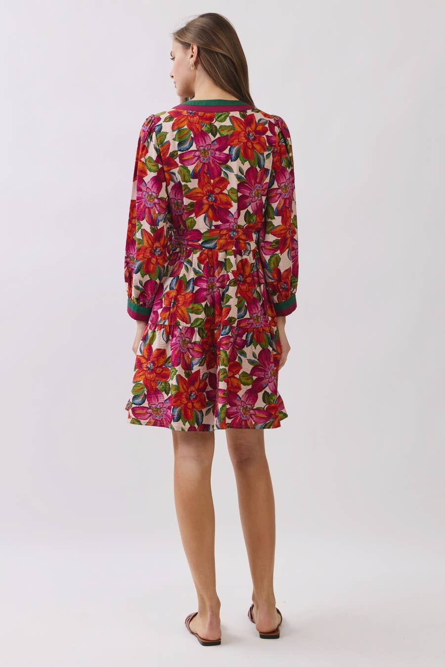 Woman wearing a colorful floral dress on a white background