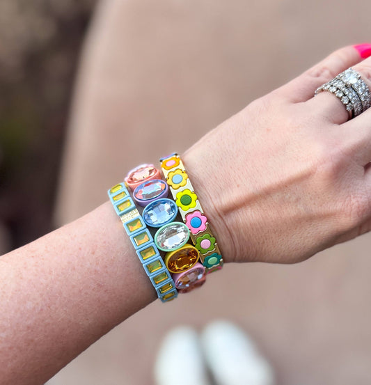 Hand wearing colorful bracelets with a blurred background