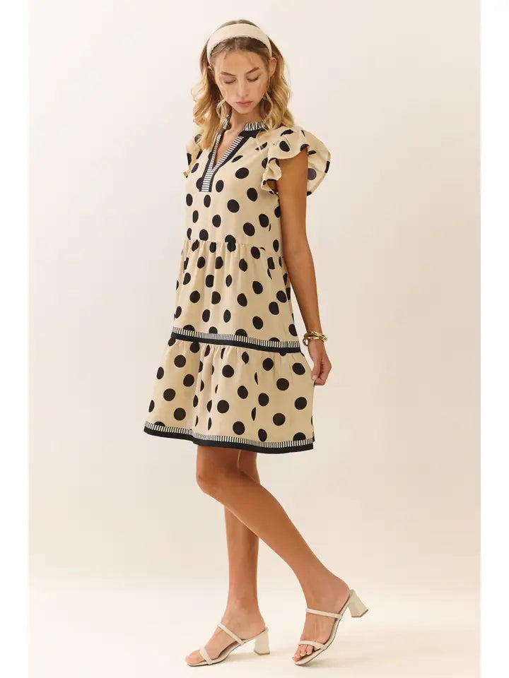 Woman wearing a polka dot dress on a plain background