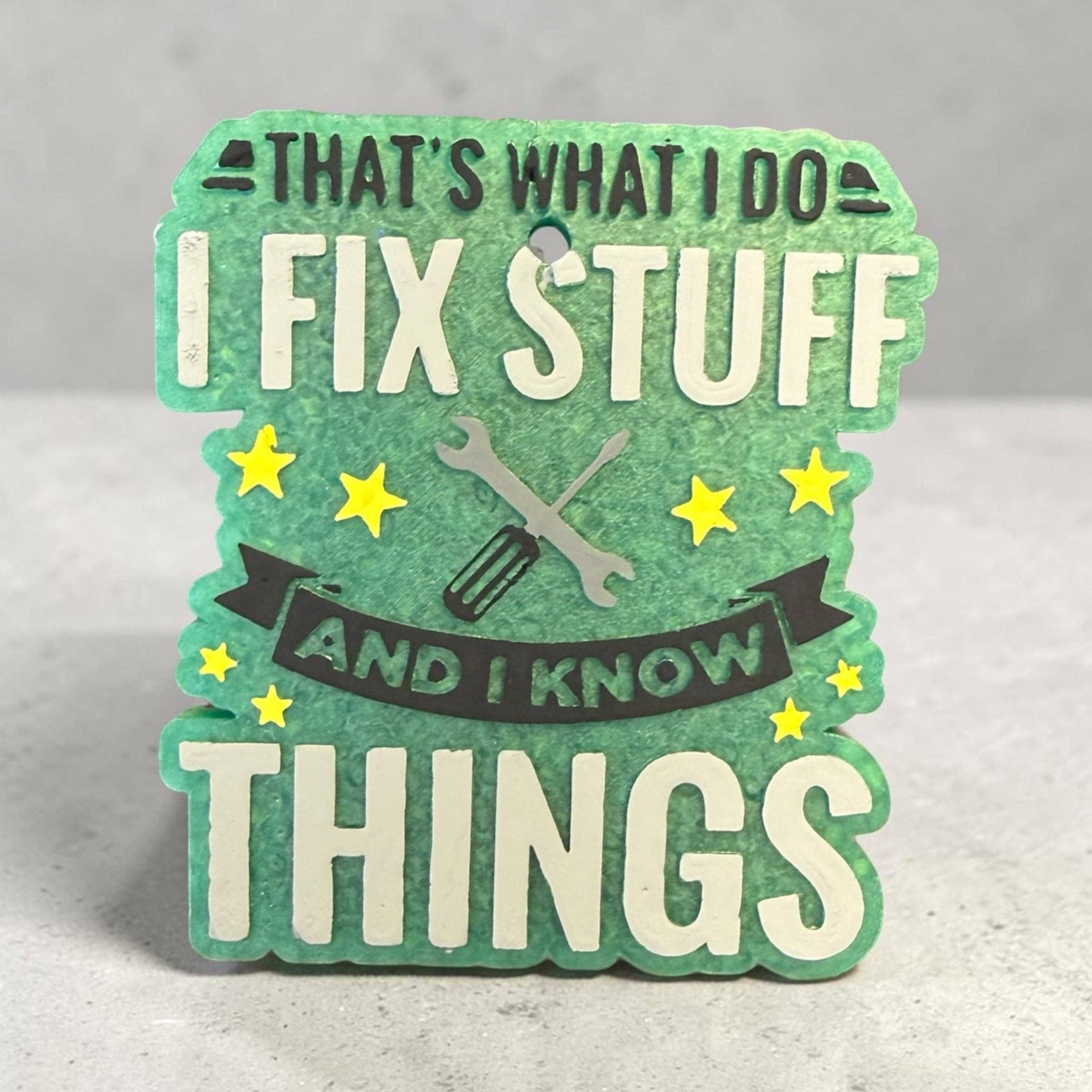 Decorative sign with text 'That's what I do, fix stuff and I know things' on a gray background