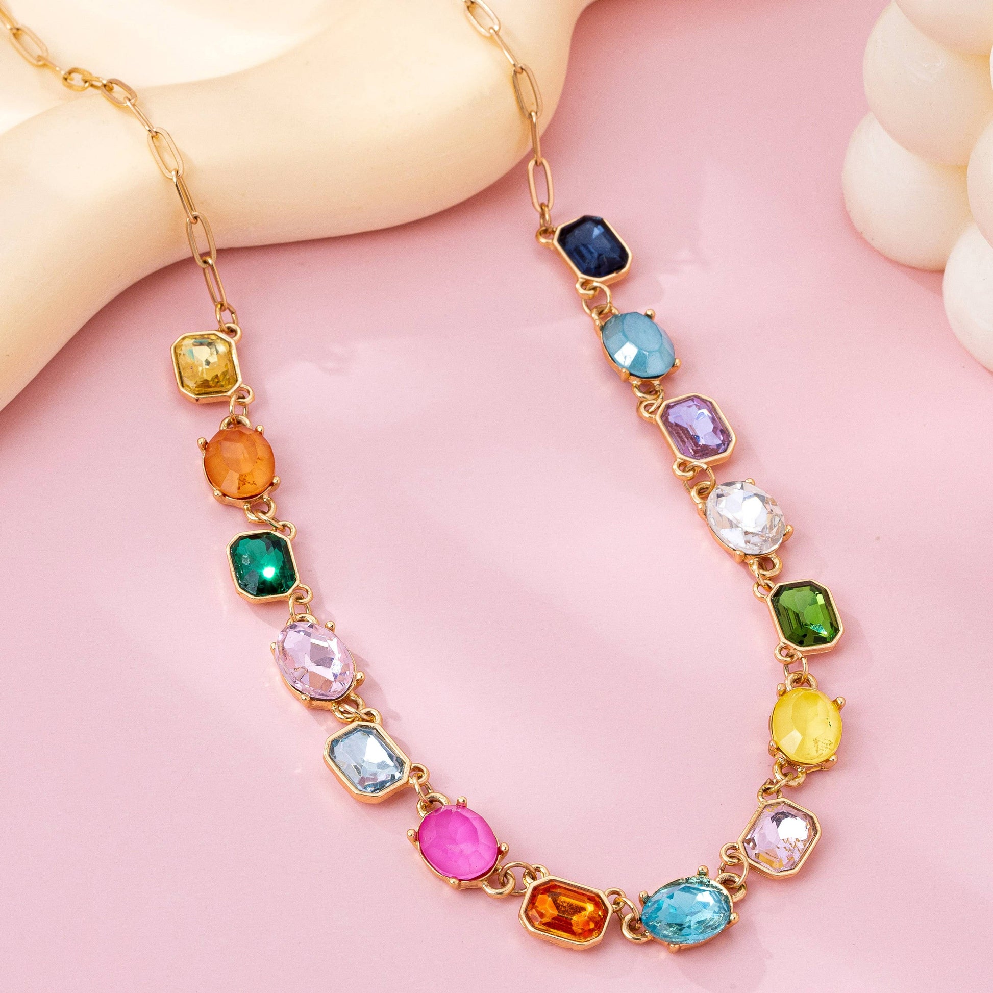 Necklace with multicolored gemstones on a pink background