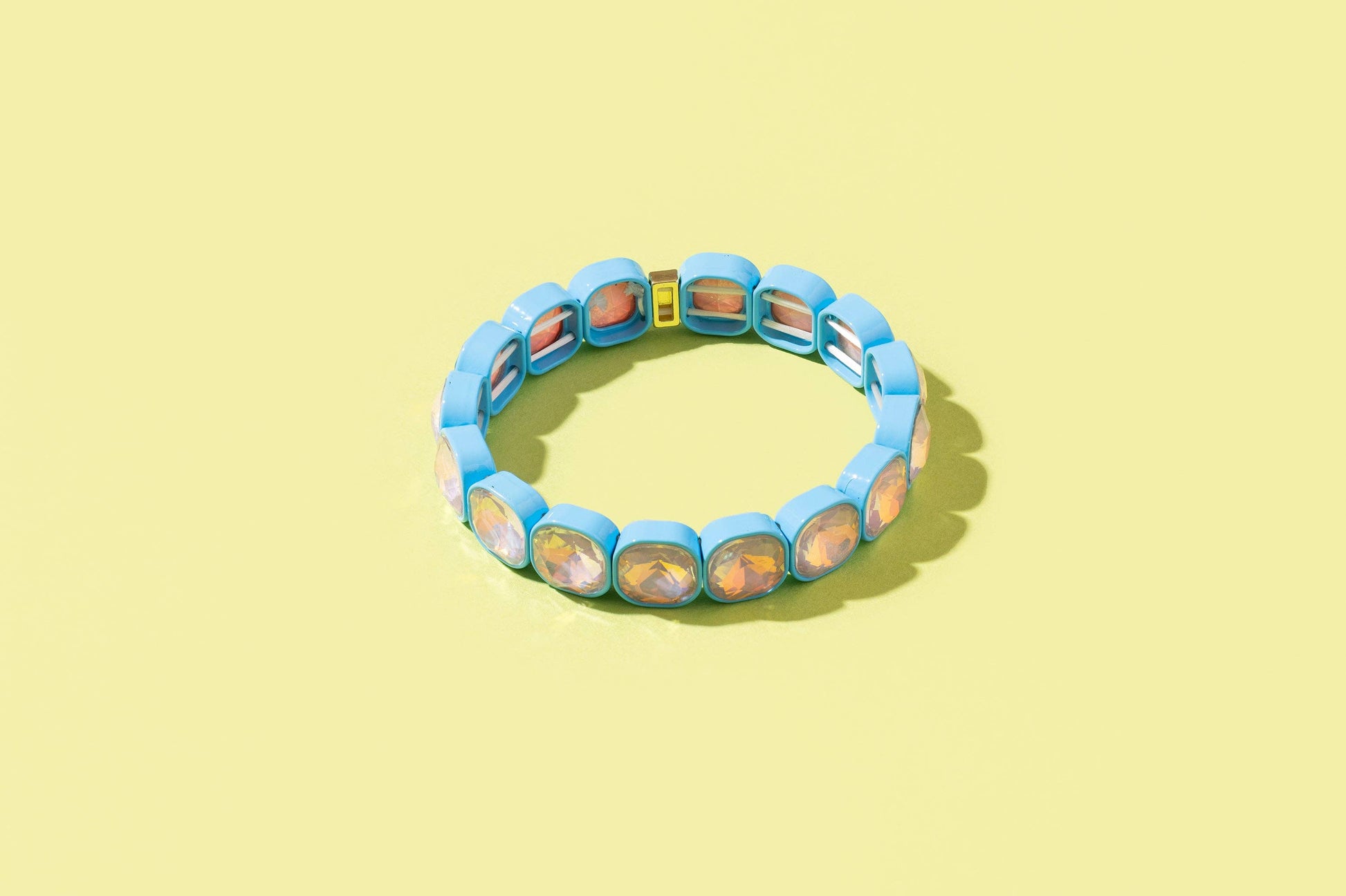 Blue bracelet with colorful stones on a yellow background