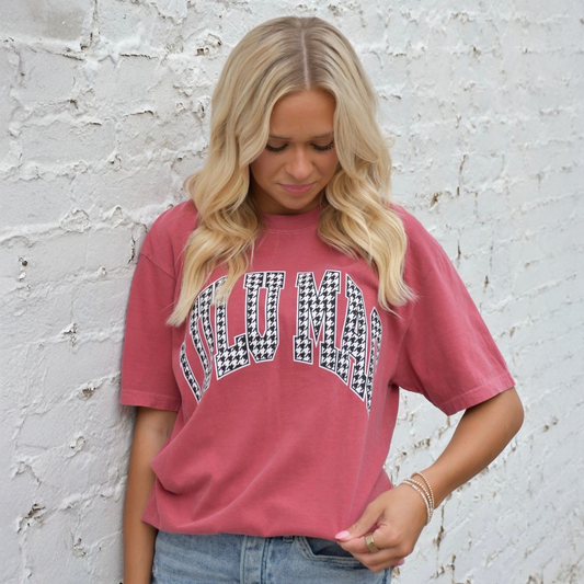 Woman wearing Lulu Mac Crimson Houndstooth Comfort Colors® Graphic Tee featuring houndstooth lettering on a crimson garment-dyed shirt.