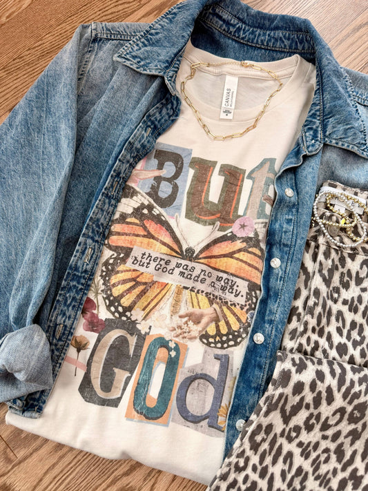T-shirt with butterfly design and text layered under a denim jacket on a wooden surface
