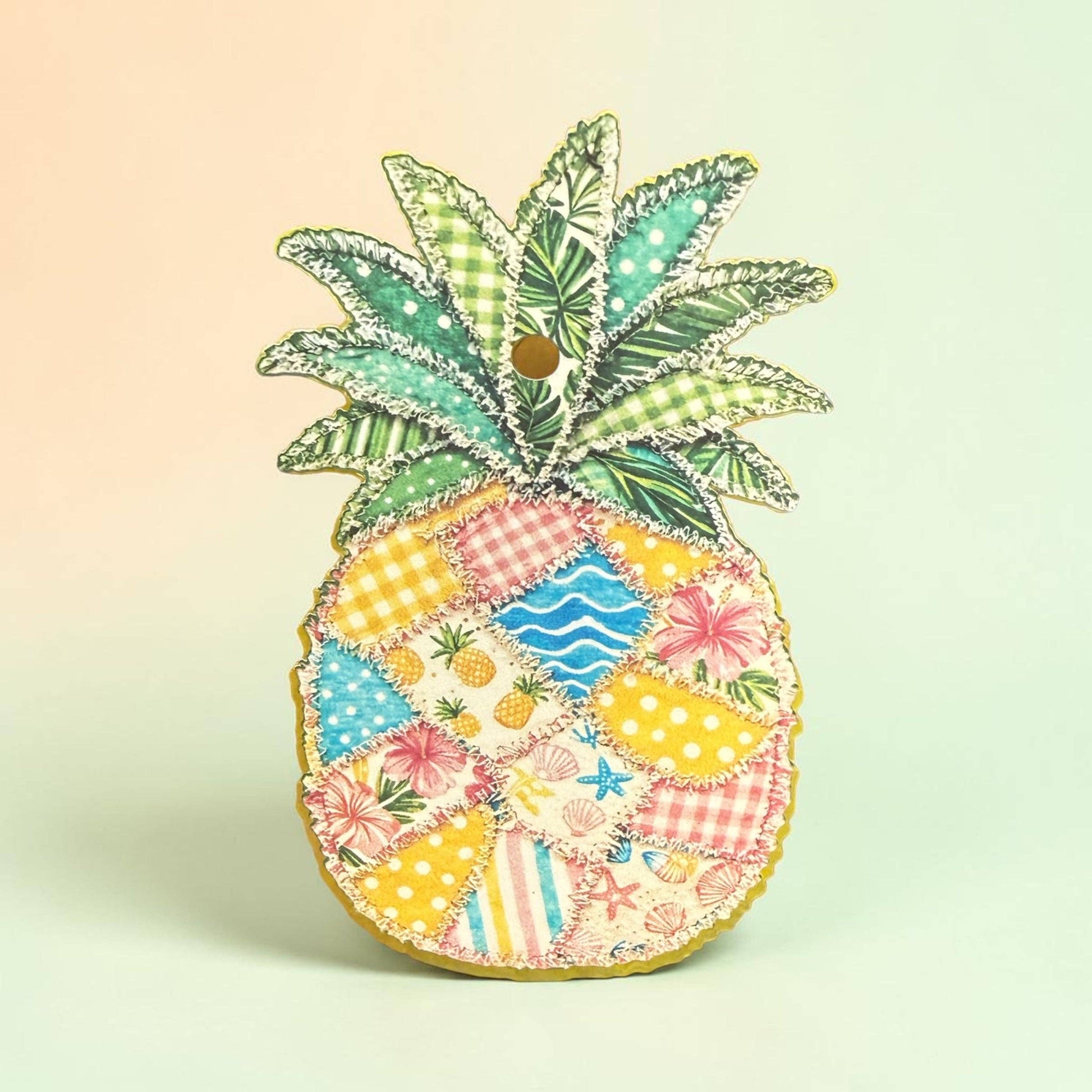 Colorful pineapple-shaped decorative item with patterned design on a light green background