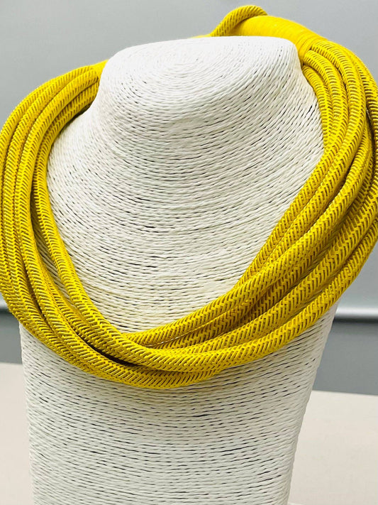 Yellow scarf on a mannequin bust against a gray background