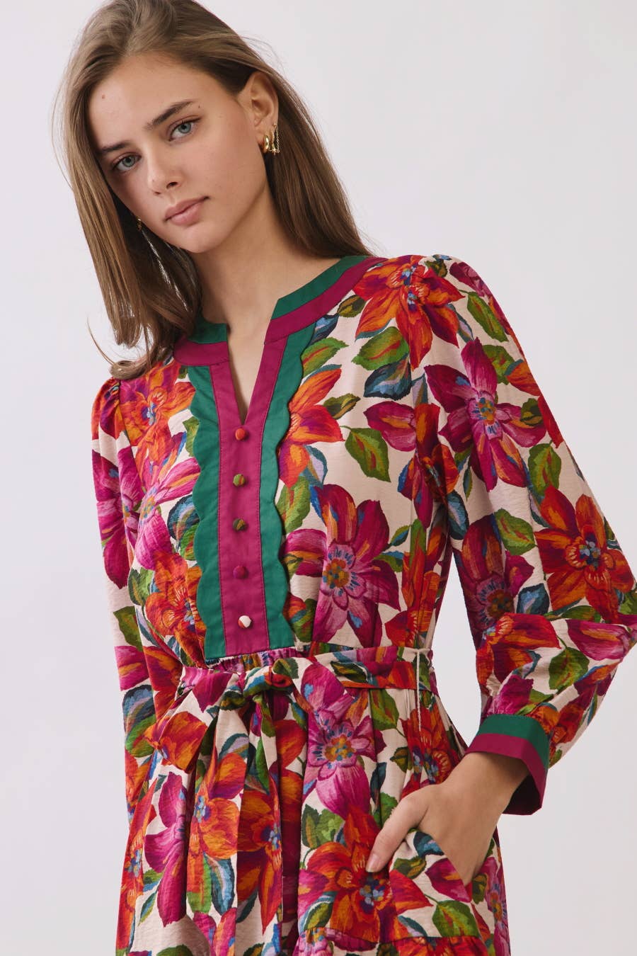 Woman wearing a colorful floral dress on a white background