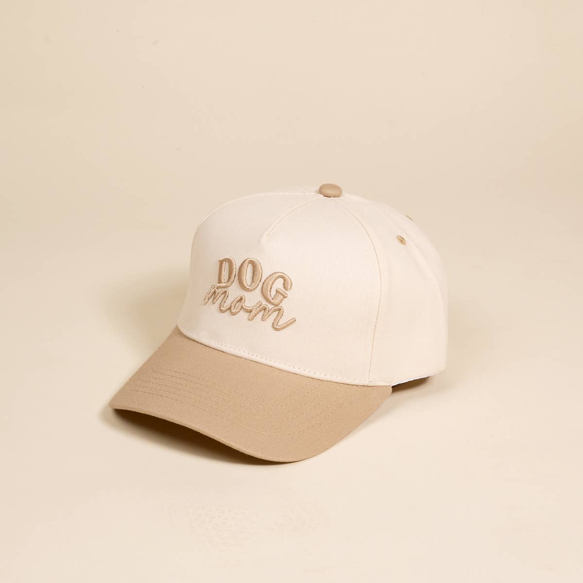 White and beige cap with 'DOG MOM' text on a beige background