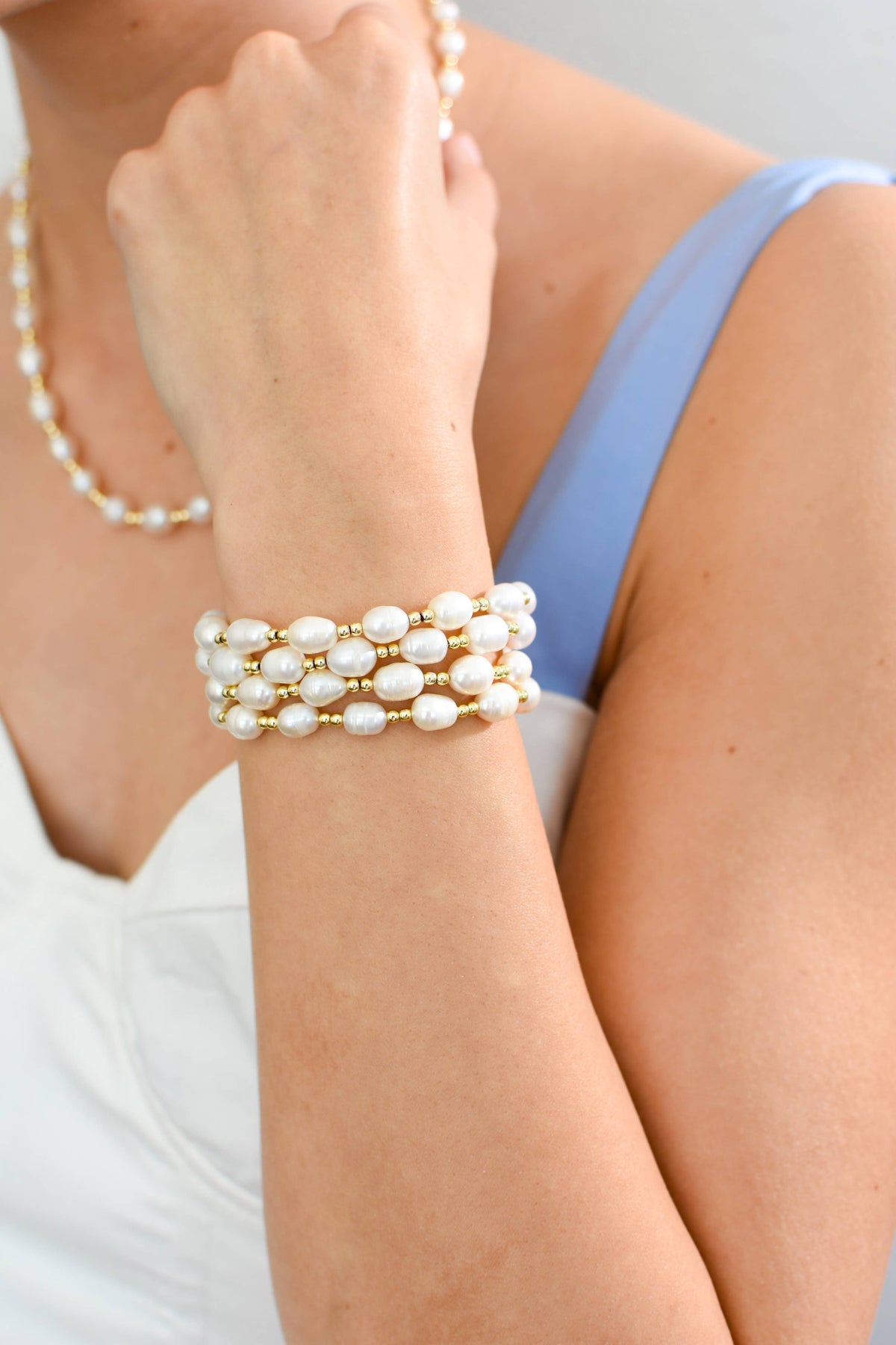 Pearl bracelet on a wrist with a neutral background