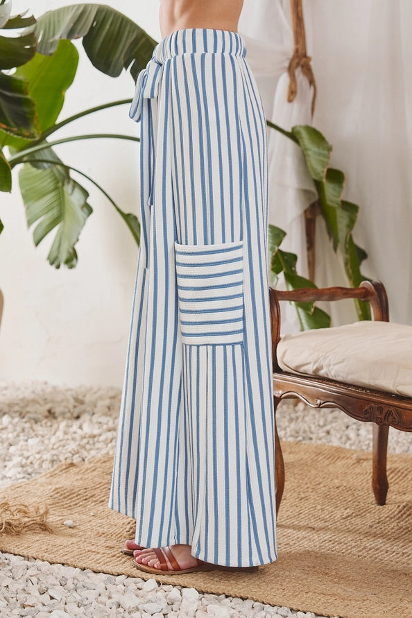 Striped wide-leg pants in indigo/cream, side view showing tie waist and patch pocket
