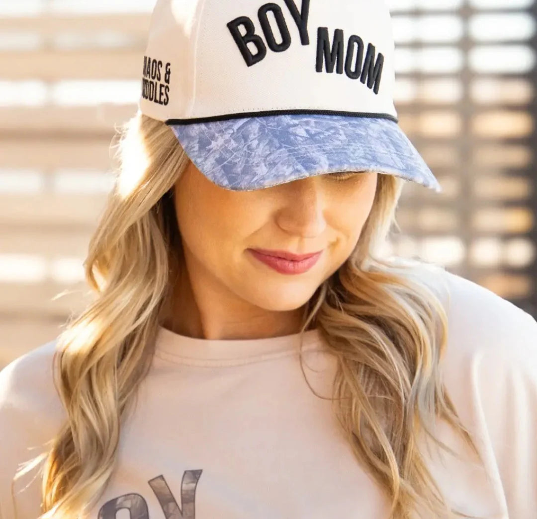 Woman wearing Boy Mom Chaos and Cuddles trucker hat with acid wash denim brim and cream crown