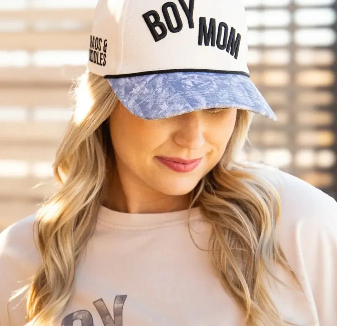 Woman wearing Boy Mom Chaos and Cuddles trucker hat with acid wash denim brim and cream crown