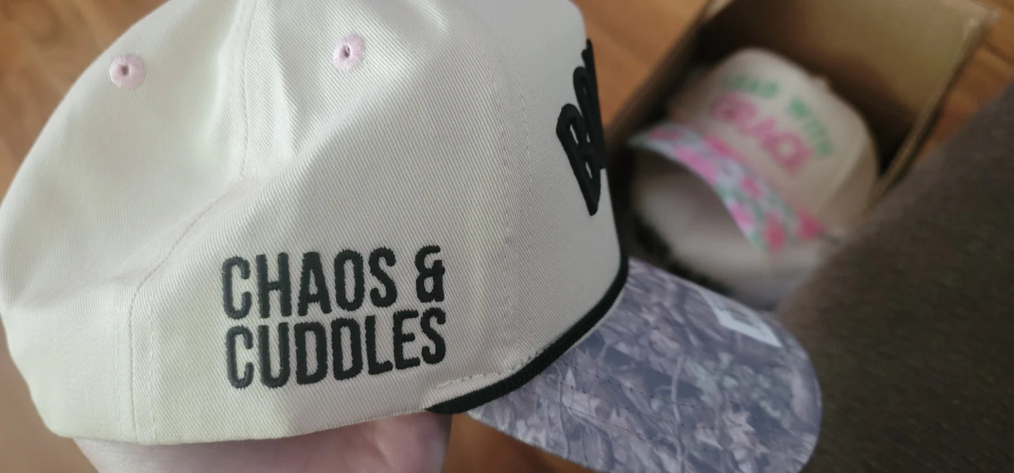 Close up of Boy Mom Chaos and Cuddles embroidery on cream trucker hat with black rope trim and acid wash brim